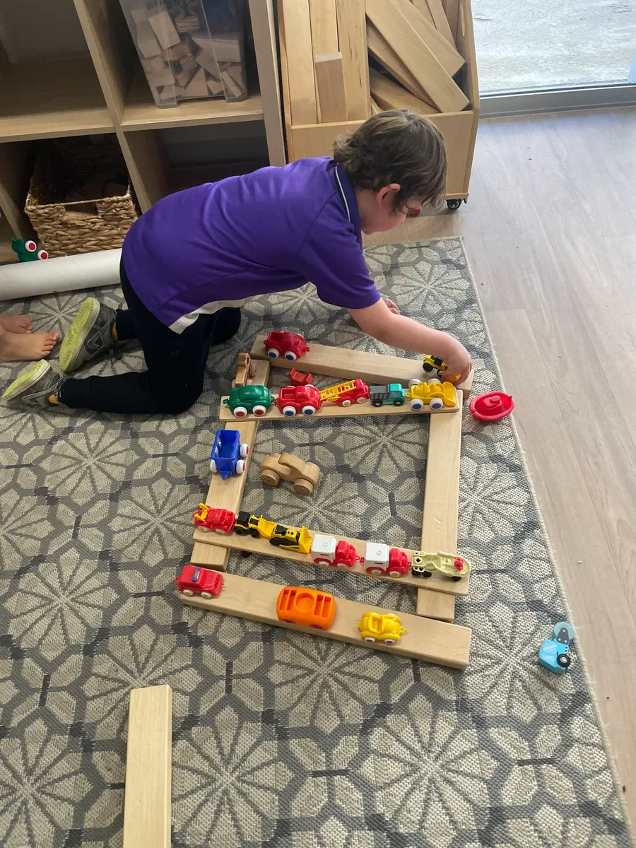 Toddler playing with wooden blocks instead of screen at Perth childcare centre