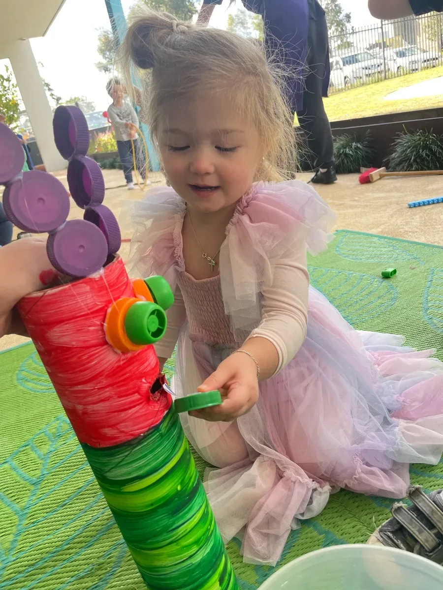 Toddler making a handprint Father's Day card at Perth daycare centre